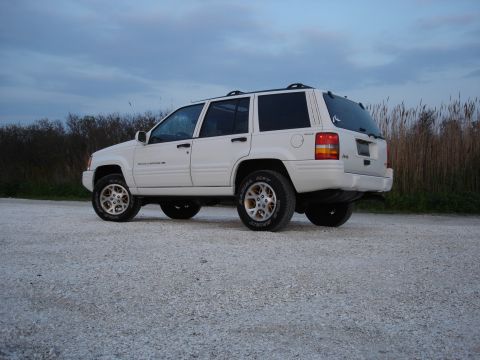 1997 Jeep Grand Cherokee - White 1997 Jeep Grand Cherokee parked on gravel under a cloudy sky.