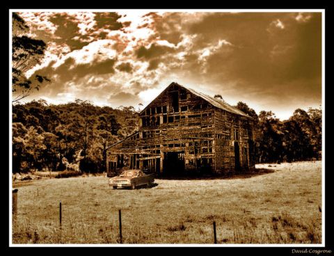 1979 Ford Ranchero - A vintage sedan sits abandoned in front of a decaying barn under a dramatic sky.