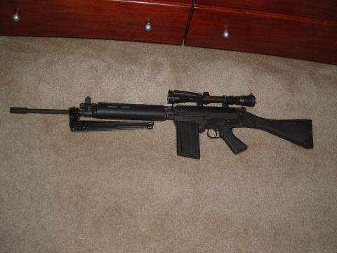 1989 Ford Bronco - A rifle with a scope and bipod is displayed on a carpeted floor.