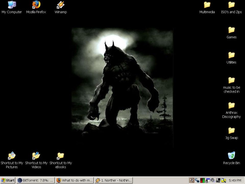 Desktop wallpaper of a werewolf standing on a rocky outcrop under a full moon