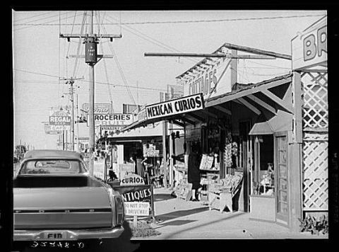 1979 Ford Ranchero - A vintage pickup truck is parked on a street with various shops and signs.