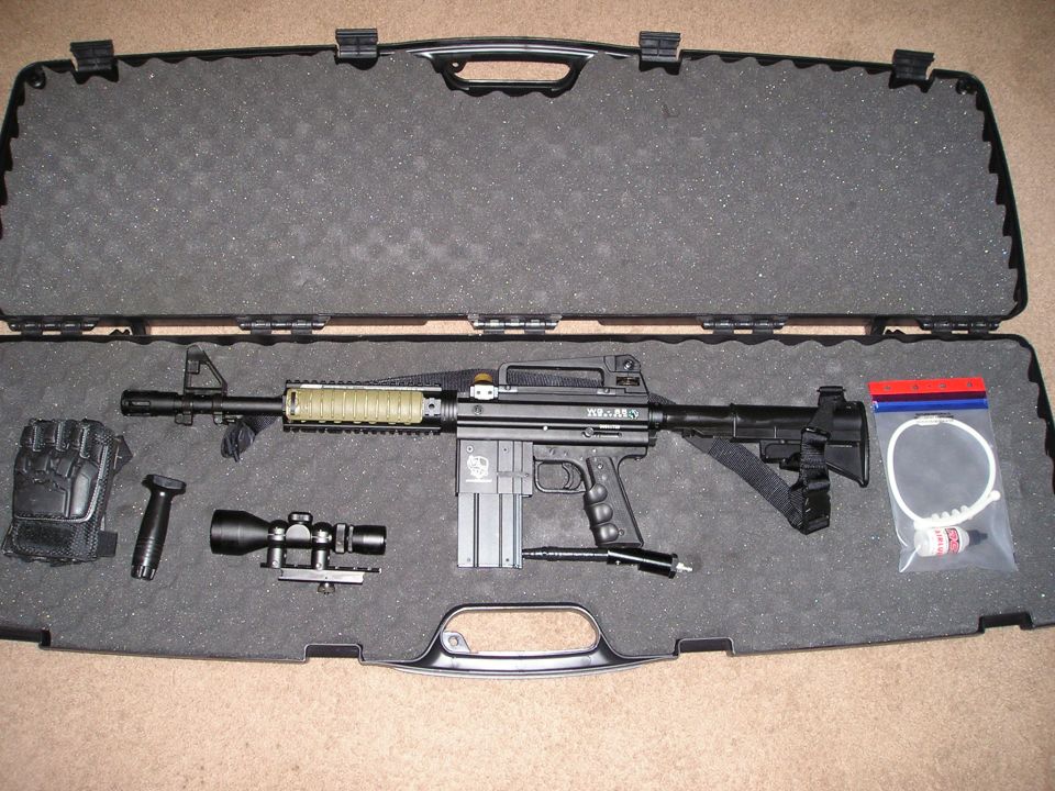 Paintball gun with scope, grip, and gloves in a black case