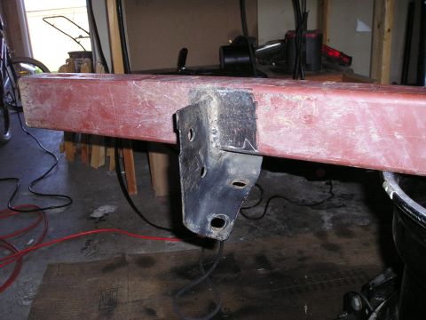 1986 Ford Bronco II - A red metal bumper section with a black metal bracket is shown in a workshop setting.