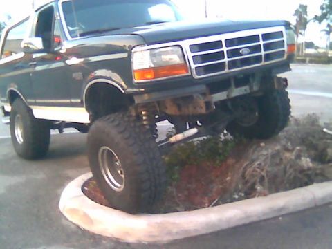 1992 Ford Bronco - This 1992 Ford Bronco is shown with its suspension lifted, driving over a curb.