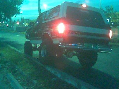 1992 Ford Bronco - Rear view of a lifted 1992 Ford Bronco with large tires, parked at dusk.