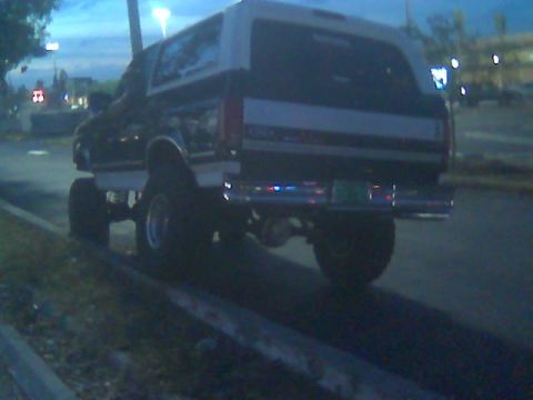 1992 Ford Bronco - This lifted SUV, possibly an early 90s Ford Bronco, is seen from the rear with a camper shell.
