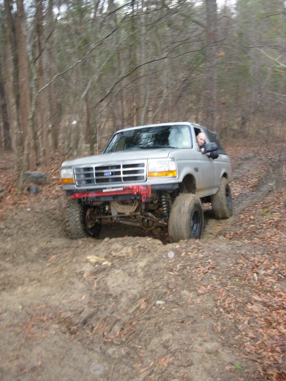 Silver 1995 Ford Bronco on muddy trail