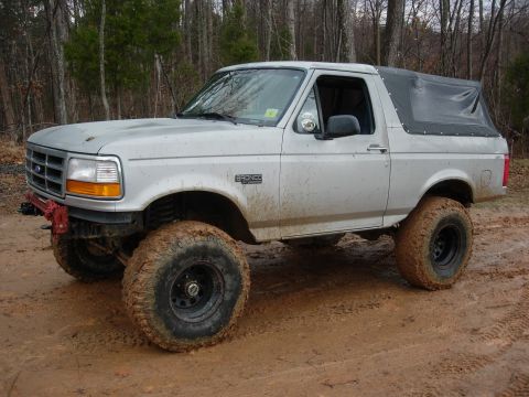 1995 Ford Bronco - This lifted Ford Bronco is equipped with large mud tires and a soft top, ready for off-road adventures.