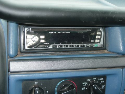 1995 Ford Bronco - Close-up of a car's dashboard, focusing on the aftermarket stereo and climate control knobs.