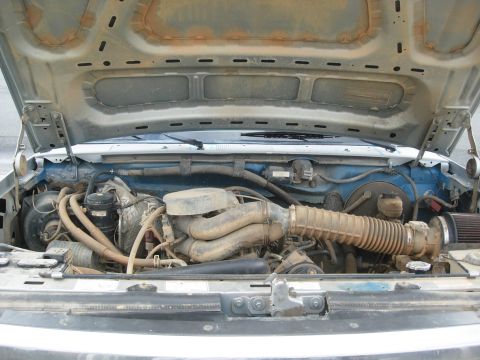 1995 Ford Bronco - Engine bay of a 1995 Ford Bronco, viewed from above with the hood raised.
