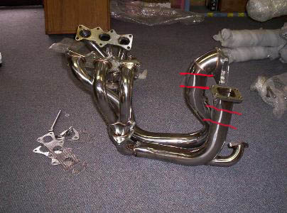 1994 Ford Probe - A chrome exhaust manifold is shown on a carpeted surface, with mounting hardware nearby.