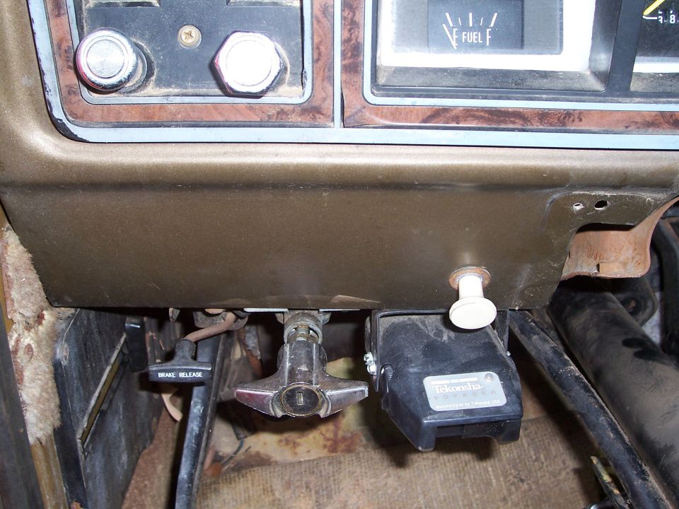 Dashboard interior with brake release lever, trailer hitch connector, and fuel gauge