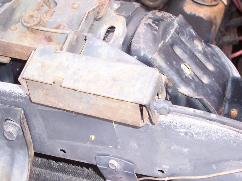 1978 Ford Bronco - Close-up view of a rusty metal bracket and cable assembly, likely a vehicle component.
