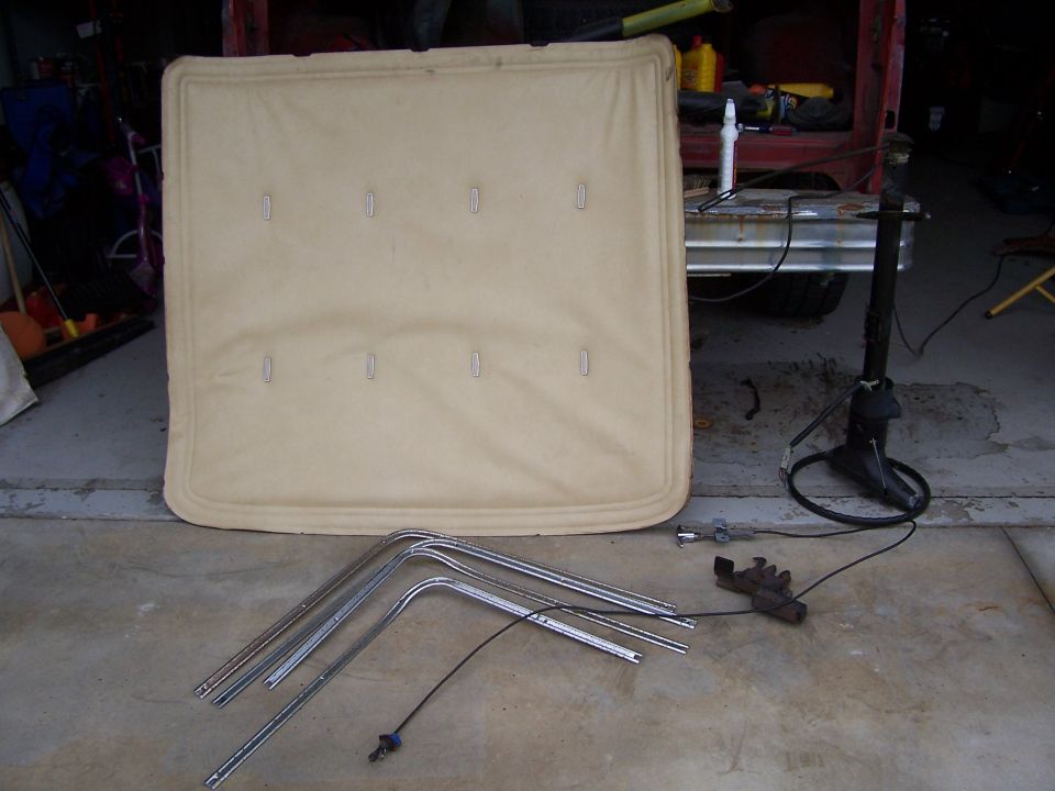 Tan headliner and chrome trim pieces on concrete floor