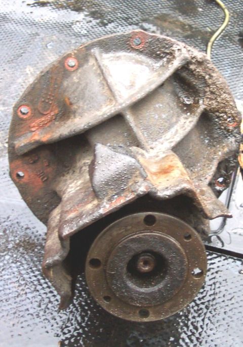 1975 Ford F-150 - A heavily corroded differential housing is shown from an angle, revealing its internal structure and a circular flange.