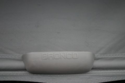 1994 Ford Bronco - The word "BRONCO" is embossed on a white cargo cover, likely from a vehicle's interior.