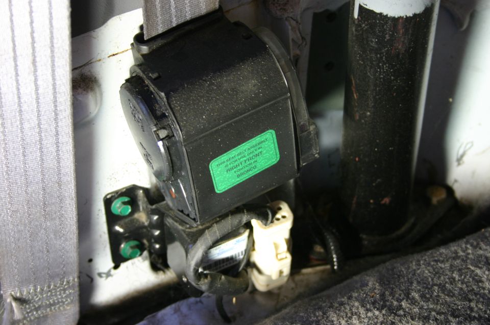 Seat belt retractor with green right-front Bronco position label at the exposed pillar