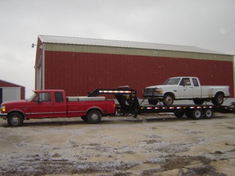 1992 Ford Bronco - A red 1992 Ford F-250 tows a trailer loaded with a white 1992 Ford F-350 pickup truck.