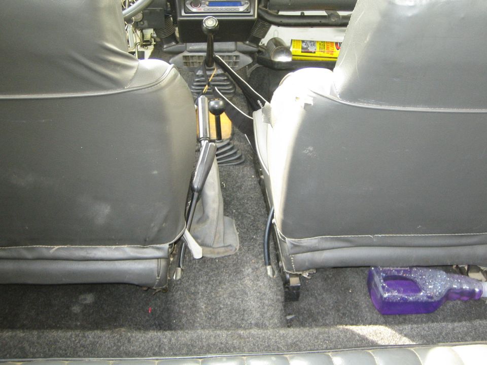 Interior shot of a vehicle, showing the front seats, gear shifters, and dashboard
