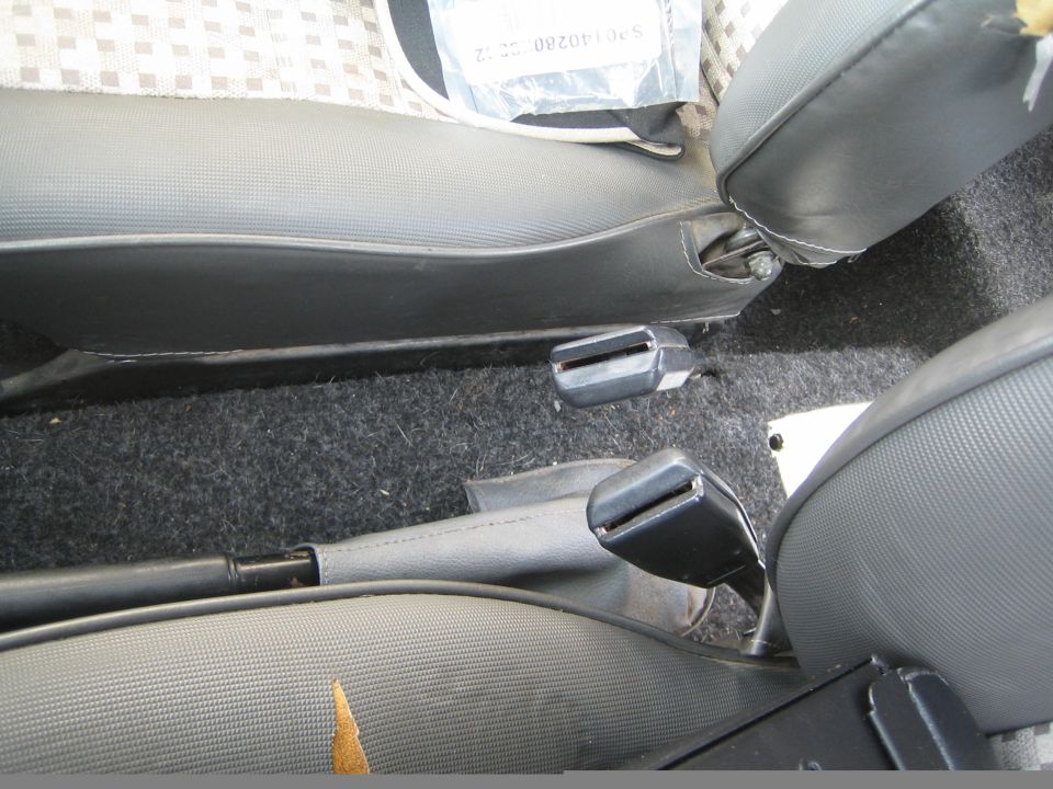 Car interior showing two seatbelt buckles and part of the seats