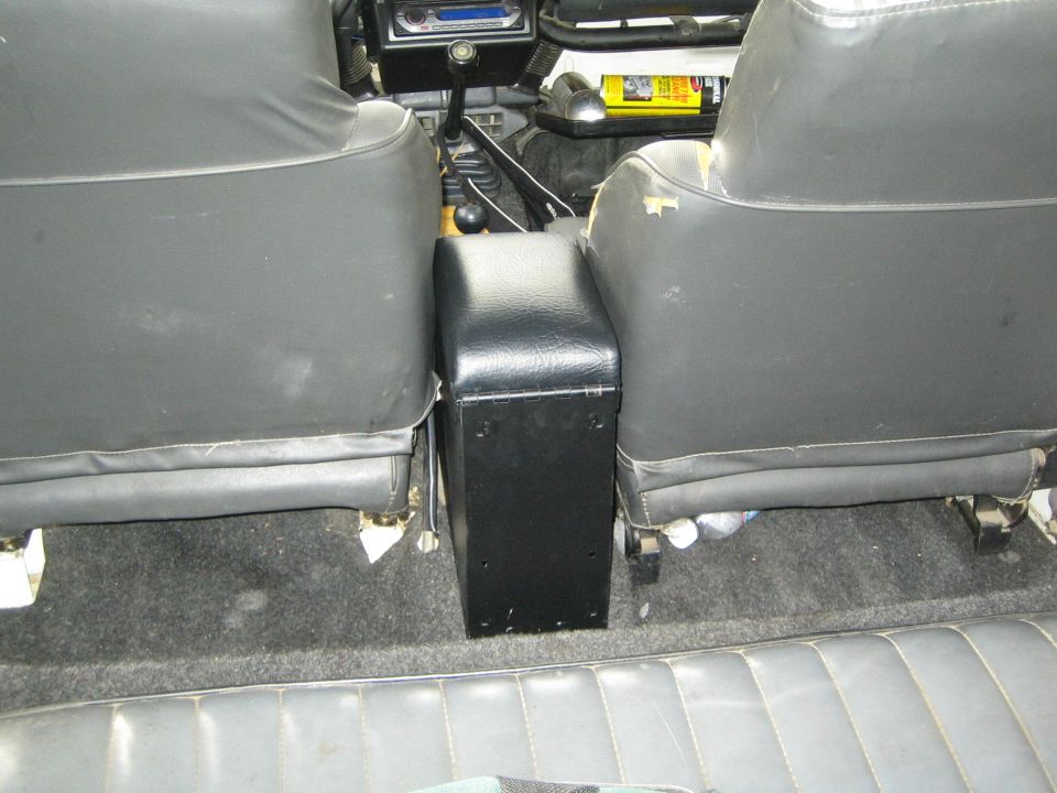 Interior view showing the gap between front bucket seats and a black center console in a vehicle