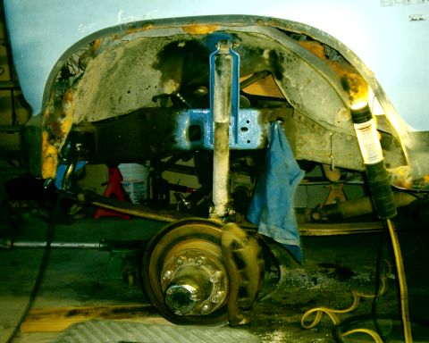 1985 Ford Bronco - The rear suspension and wheel well of a 1985 Ford Bronco, showing the shock absorber and leaf springs.