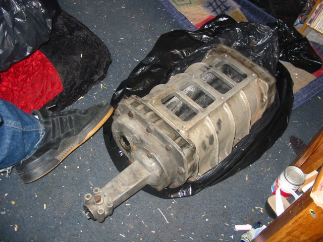 supercharger sitting on the floor next to a person's foot and some bags