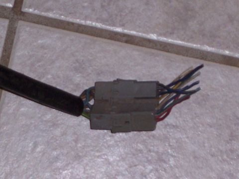 1978 Ford Bronco - A close-up view of a vehicle's wiring harness connector with several wires exposed.
