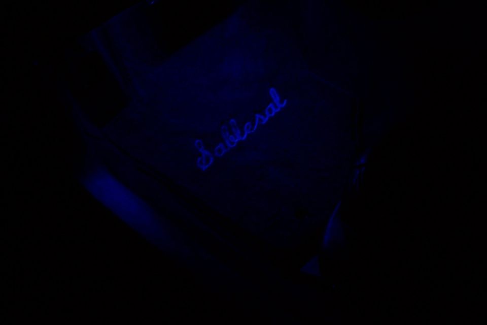 Blue illuminated 'Sable' script on a dark surface