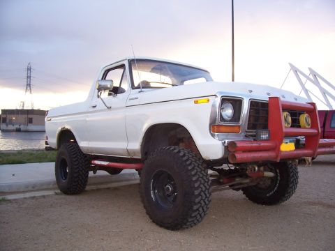 1978 Ford Bronco - This lifted 1978 Ford Bronco features a prominent red bull bar with KC lights, suggesting off-road modifications.