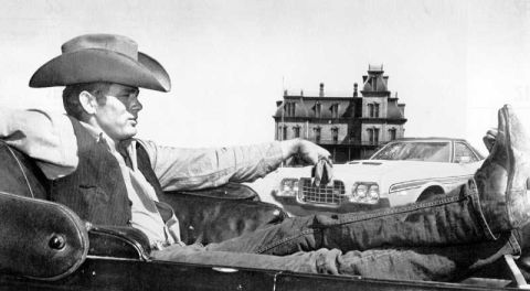 1979 Ford Ranchero - A man relaxes in a car, with a 1972 Ford Gran Torino and an old building visible in the background.