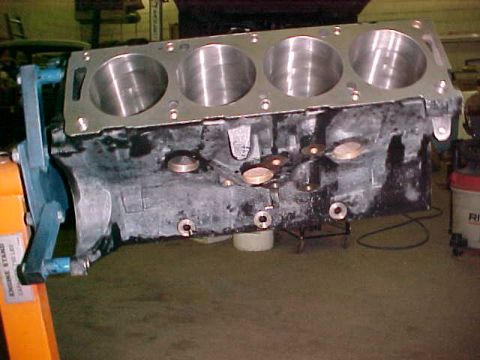 1967 Ford Galaxie - An engine block is mounted on an orange engine stand, ready for assembly or inspection.