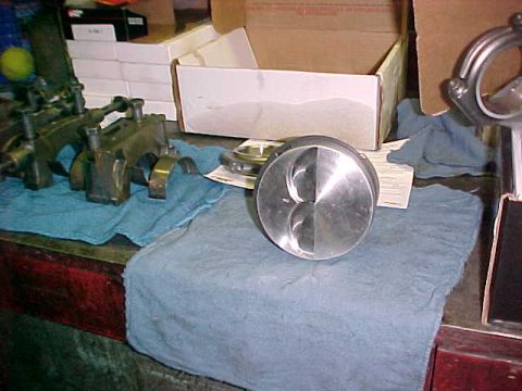 1967 Ford Galaxie - Engine parts, including a piston and connecting rod, are laid out on a workbench.