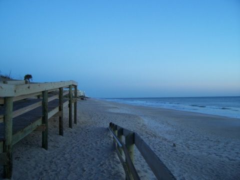 1994 Ford Probe - A view of a beach boardwalk leading to the ocean at dusk.