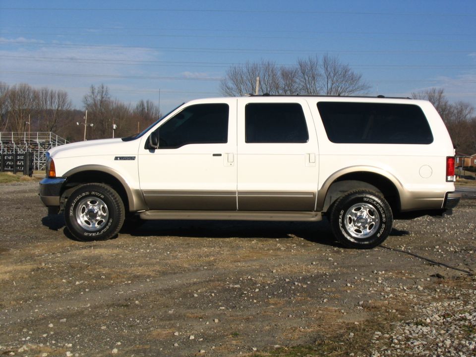White 2000 Ford Excursion parked on gravel lot, side view