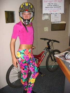 1991 Ford Bronco - Person in colorful outfit and helmet poses with a mountain bike indoors.