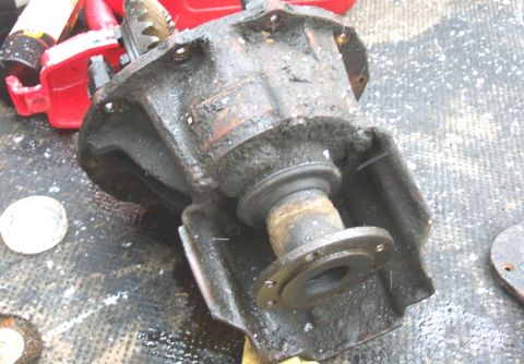 1975 Ford F-150 - Differential housing part, covered in grease, with a flange and shaft.
