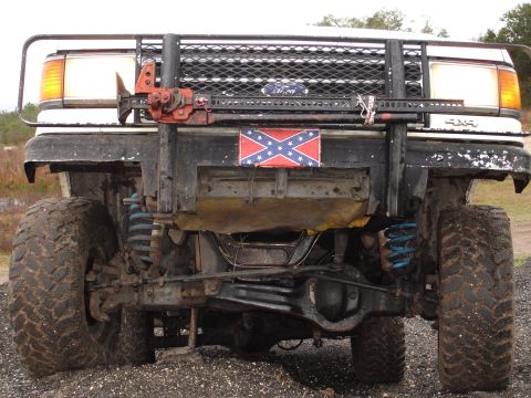 1989 Ford Bronco - This modified Ford Bronco features a winch and off-road tires, with a Confederate flag displayed on the front.