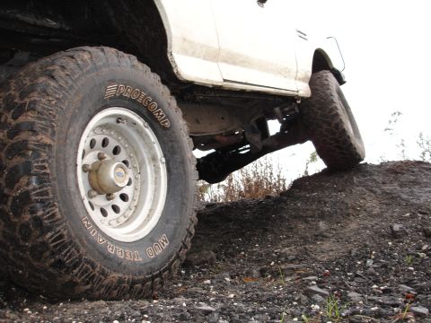 1989 Ford Bronco - This truck is positioned on a dirt mound, with its large off-road tires clearly visible.