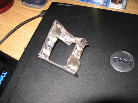 1995 Ford Bronco - A close-up view of a crudely welded metal bracket attached to the lid of a Dell laptop.