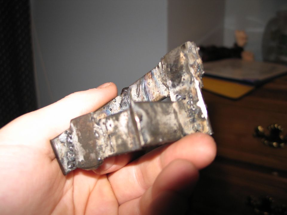 Welded metal bracket held in hand
