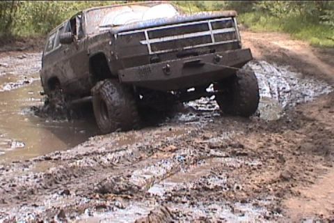 1977 Ford F-150 - This SUV is stuck in a mud pit on a dirt road.