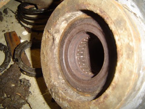 1979 Ford Bronco - Close-up of a heavily corroded axle hub, showing internal splines and surrounding damaged metal.