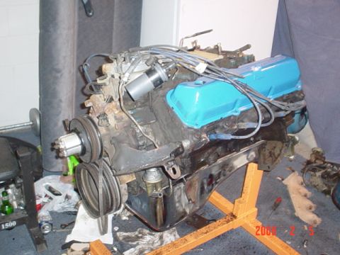 1979 Ford Bronco - Engine assembly on an orange stand, blue valve covers and visible pulleys.