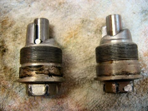 1985 Ford LTD Crown Victoria - Close-up view of two carburetor components, showing wear and grime on the threaded sections.