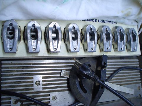 1984 Ford Bronco - Eight aluminum roller rocker arms are displayed in a holder, with electronic equipment visible underneath.