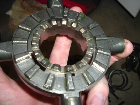 1999 Jeep Grand Cherokee - A metal gear synchronizer ring with visible teeth and a finger in the center is held for inspection.