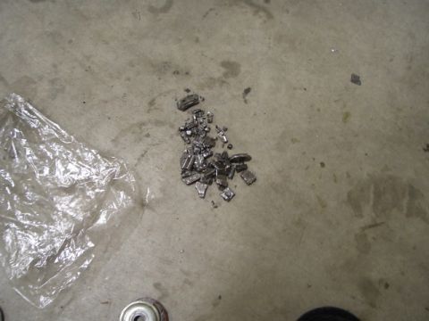 1999 Jeep Grand Cherokee - Broken wheel weights scattered on a garage floor, possibly indicating a recent tire or wheel service.