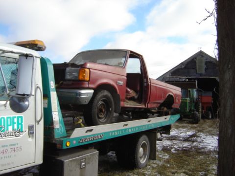1992 Ford Bronco - A red 1992 Ford F-350 pickup truck is being towed, with a barn and tractors in the background.