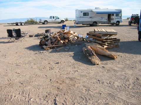1997 Ford Ranger - A desert scene shows a campsite set up with an RV, pickup truck, and SUV, along with firewood and chairs.